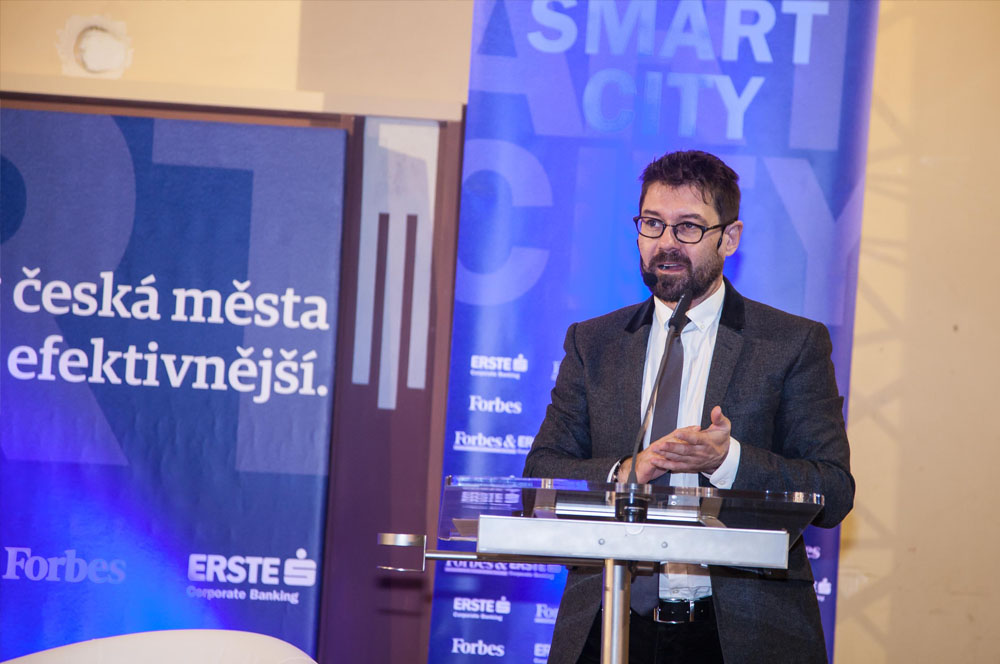 Řečník za pultem na konferenci Forbes Smart City